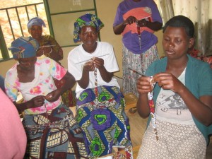Women making cloth beads for income